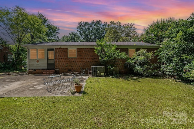 3939 Sheffield Dr, Charlotte, NC 28205 - back of property at dusk featuring a patio area, a lawn, and crawl space