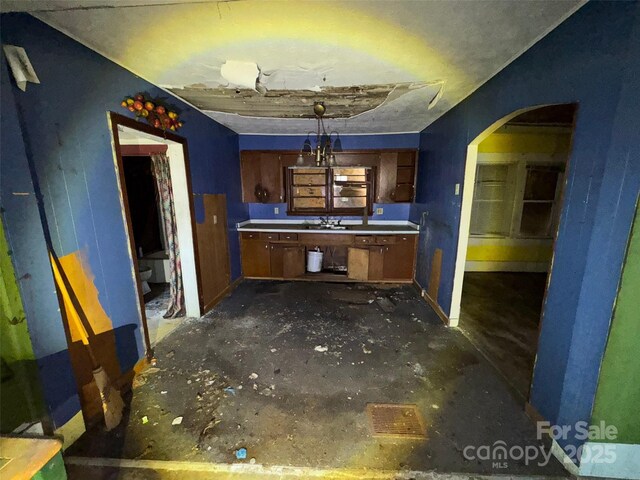 15 Vine St, Canton, NC 28716 - kitchen featuring arched walkways, a sink, light countertops, brown cabinets, and baseboards