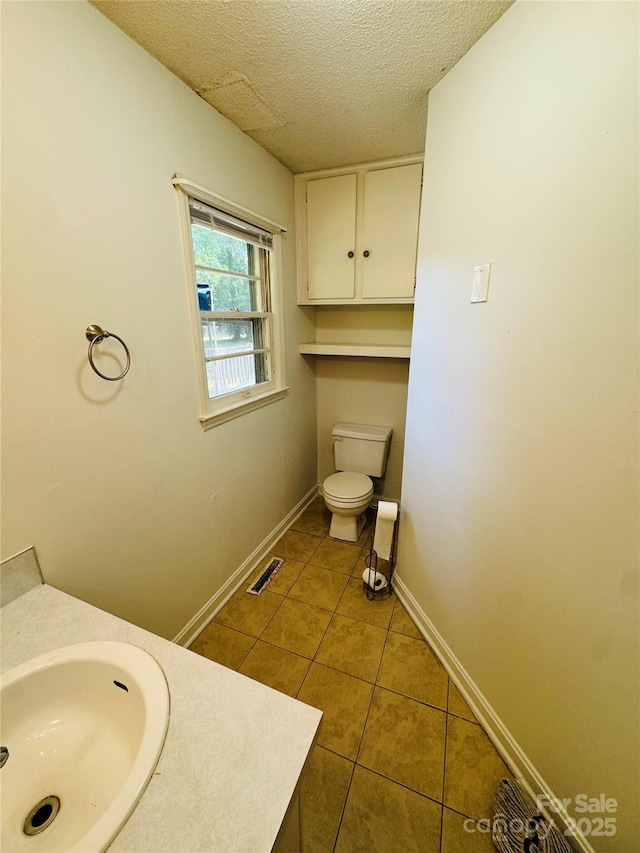 316 Meadowood Cir, Kannapolis, NC 28081 - bathroom with tile patterned floors, toilet, a textured ceiling, baseboards, and vanity