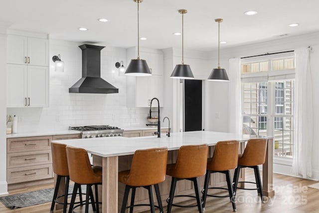 2018 Whiskery Ct, York, SC 29745 - kitchen featuring wall chimney range hood, tasteful backsplash, light countertops, an island with sink, and pendant lighting
