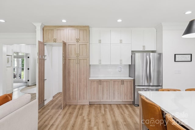 2018 Whiskery Ct, York, SC 29745 - kitchen featuring freestanding refrigerator, crown molding, light wood finished floors, light countertops, and backsplash