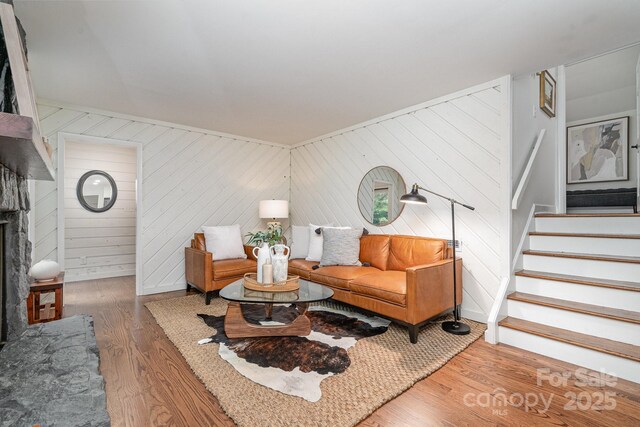1601 Wandering Way Dr, Charlotte, NC 28226 - living area featuring wood finished floors, stairs, a fireplace with raised hearth, and wooden walls
