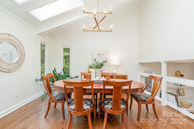 1601 Wandering Way Dr, Charlotte, NC 28226 - dining room with vaulted ceiling, light wood-style floors, a chandelier, a skylight, and ornamental molding