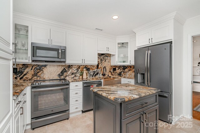 1601 Wandering Way Dr, Charlotte, NC 28226 - kitchen featuring appliances with stainless steel finishes, white cabinets, light stone countertops, tasteful backsplash, and crown molding