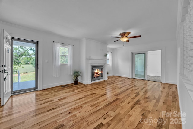 3804 Lippard Ln, Valdese, NC 28690 - unfurnished living room with light wood finished floors, a glass covered fireplace, ceiling fan, and baseboards