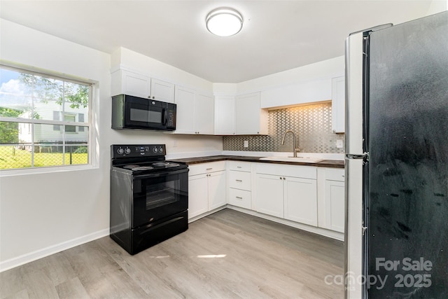 112 Lineberger St, Stanley, NC 28164 - kitchen featuring black appliances, light wood-style flooring, white cabinetry, and backsplash