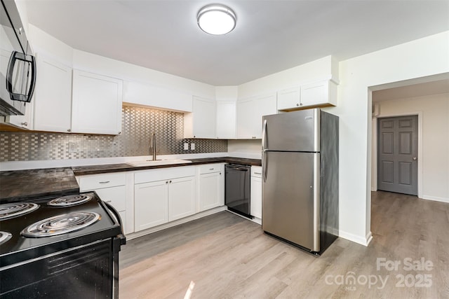112 Lineberger St, Stanley, NC 28164 - kitchen with black appliances, light wood-type flooring, white cabinets, tasteful backsplash, and dark countertops