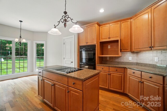 3735 Gordon St, Terrell, NC 28682 - kitchen with black appliances, light wood-style floors, a center island, tasteful backsplash, and decorative light fixtures