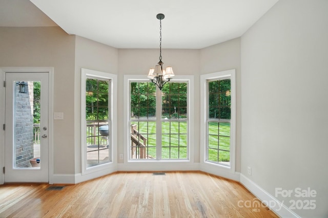 3735 Gordon St, Terrell, NC 28682 - unfurnished dining area with wood finished floors, a chandelier, healthy amount of natural light, and baseboards