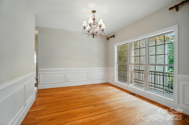 3735 Gordon St, Terrell, NC 28682 - unfurnished room with a chandelier, light wood finished floors, wainscoting, and a decorative wall