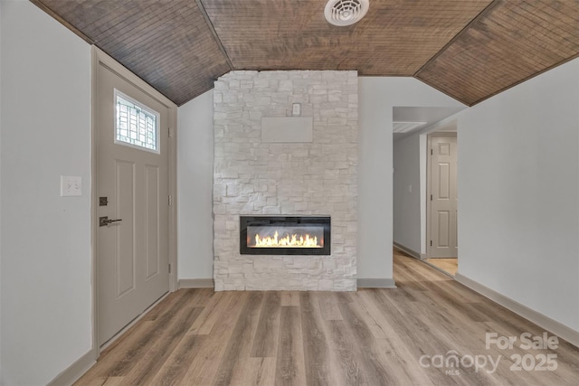 1598 Claybank Rd, West Jefferson, NC 28694 - unfurnished living room with a stone fireplace, vaulted ceiling, wood finished floors, and baseboards