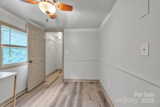 1598 Claybank Rd, West Jefferson, NC 28694 - unfurnished bedroom with light wood finished floors, baseboards, a spacious closet, and ceiling fan