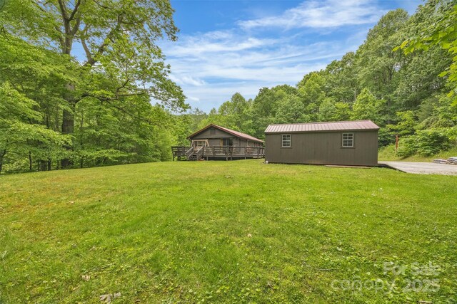 1598 Claybank Rd, West Jefferson, NC 28694 - view of grassy yard featuring a wooden deck, a wooded view, and an outdoor structure