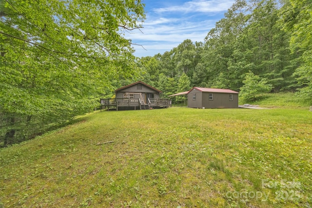 1598 Claybank Rd, West Jefferson, NC 28694 - view of grassy yard with a wooden deck, an outbuilding, and a view of trees