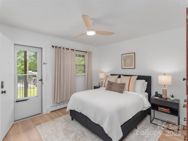 130 Old Mill Rd Unit 222, Flat Rock, NC 28731 - bedroom featuring a baseboard radiator, light wood finished floors, multiple windows, and access to outside