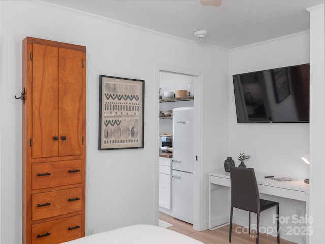 130 Old Mill Rd Unit 222, Flat Rock, NC 28731 - bedroom with crown molding, freestanding refrigerator, light wood-type flooring, and a desk