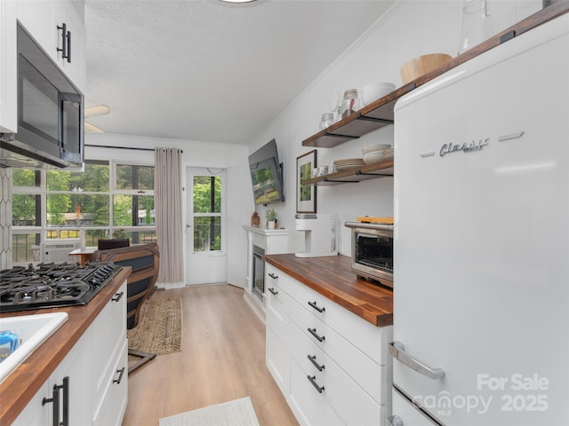 130 Old Mill Rd Unit 222, Flat Rock, NC 28731 - kitchen with butcher block countertops, fridge, open shelves, light wood-style floors, and black gas stovetop