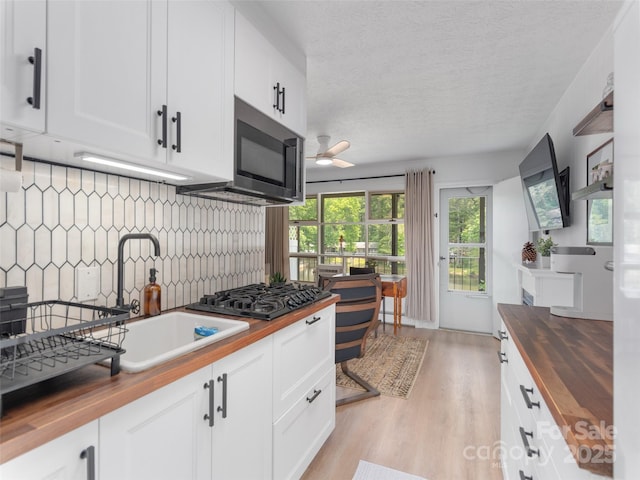 130 Old Mill Rd Unit 222, Flat Rock, NC 28731 - kitchen featuring butcher block countertops, black gas stovetop, light wood-style flooring, a ceiling fan, and decorative backsplash