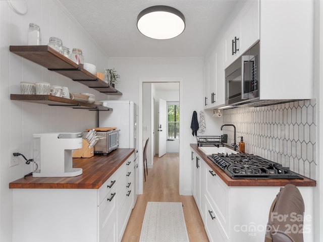 130 Old Mill Rd Unit 222, Flat Rock, NC 28731 - kitchen featuring wood counters, stainless steel microwave, black gas cooktop, light wood-style floors, and a sink