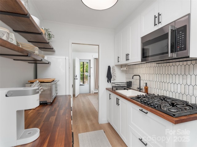 130 Old Mill Rd Unit 222, Flat Rock, NC 28731 - kitchen featuring butcher block counters, black gas stovetop, stainless steel microwave, decorative backsplash, and a sink