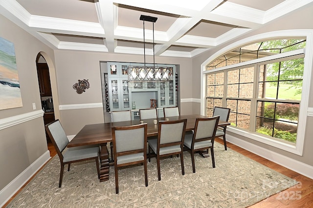 6302 Dwayne Starnes Dr, Hickory, NC 28602 - dining room featuring coffered ceiling, arched walkways, baseboards, beam ceiling, and wood finished floors