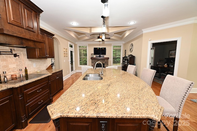 6302 Dwayne Starnes Dr, Hickory, NC 28602 - kitchen featuring black electric cooktop, a sink, ceiling fan, a center island with sink, and backsplash
