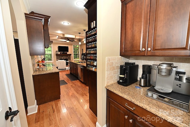 6302 Dwayne Starnes Dr, Hickory, NC 28602 - kitchen with ceiling fan, a fireplace, light wood-style flooring, a sink, and tasteful backsplash