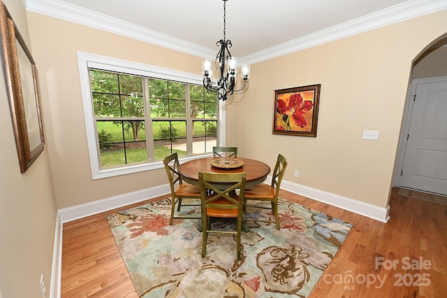 6302 Dwayne Starnes Dr, Hickory, NC 28602 - dining room featuring a chandelier, arched walkways, ornamental molding, baseboards, and wood finished floors