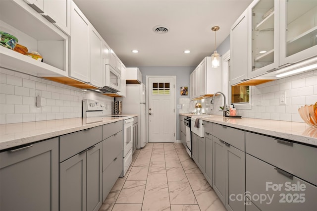 44 Jervey Rd Unit 3A, Tryon, NC 28782 - kitchen featuring white appliances, light marble finish floors, gray cabinetry, recessed lighting, and glass insert cabinets