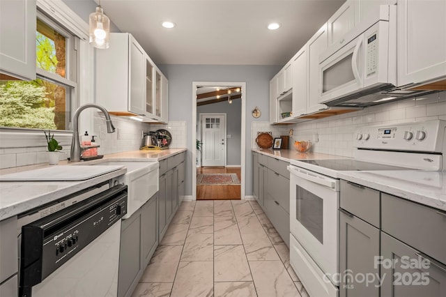 44 Jervey Rd Unit 3A, Tryon, NC 28782 - kitchen featuring white appliances, light marble finish flooring, gray cabinetry, light stone countertops, and backsplash