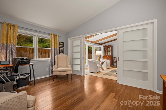 44 Jervey Rd Unit 3A, Tryon, NC 28782 - living area featuring lofted ceiling, wood finished floors, an office area, french doors, and baseboards