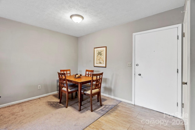 427 6th Ave W Unit B-8, Hendersonville, NC 28739 - dining space featuring baseboards, a textured ceiling, and light wood-type flooring