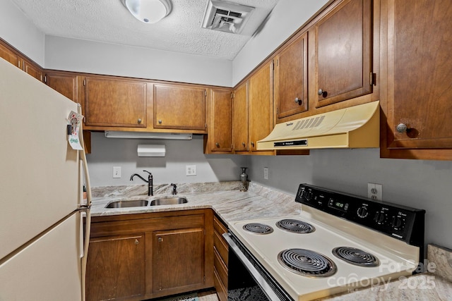 427 6th Ave W Unit B-8, Hendersonville, NC 28739 - kitchen featuring electric stove, under cabinet range hood, freestanding refrigerator, a sink, and a textured ceiling