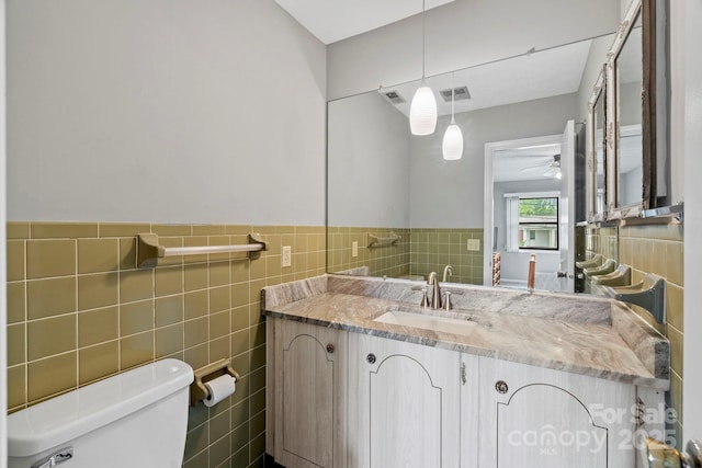 427 6th Ave W Unit B-8, Hendersonville, NC 28739 - half bath with tile walls, toilet, vanity, a ceiling fan, and a wainscoted wall