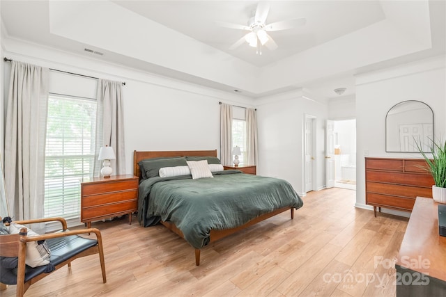 502 Roxanne Ct NW, Concord, NC 28027 - bedroom with a raised ceiling, multiple windows, light wood-type flooring, and ensuite bath