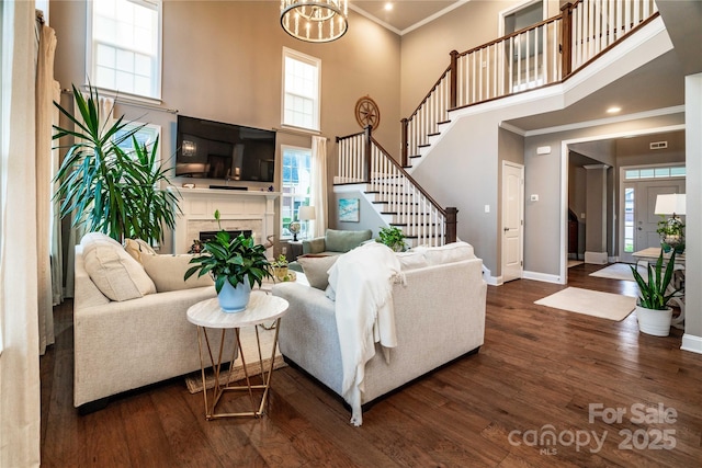 159 Holly Ridge Dr, Mooresville, NC 28115 - living room with crown molding, baseboards, wood finished floors, a high ceiling, and stairs