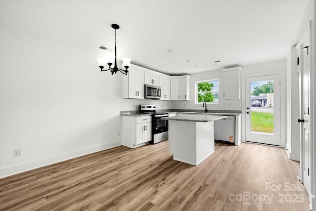 1600/1602 Bluff St, Albemarle, NC 28001 - kitchen with appliances with stainless steel finishes, a chandelier, white cabinetry, light wood-type flooring, and baseboards