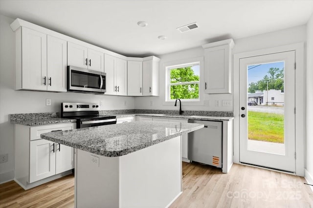 1600/1602 Bluff St, Albemarle, NC 28001 - kitchen featuring stainless steel appliances, a sink, light wood-type flooring, light stone counters, and a kitchen island