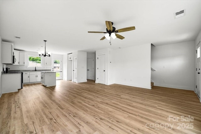 1600/1602 Bluff St, Albemarle, NC 28001 - unfurnished living room with a chandelier, ceiling fan, baseboards, light wood-type flooring, and stairway