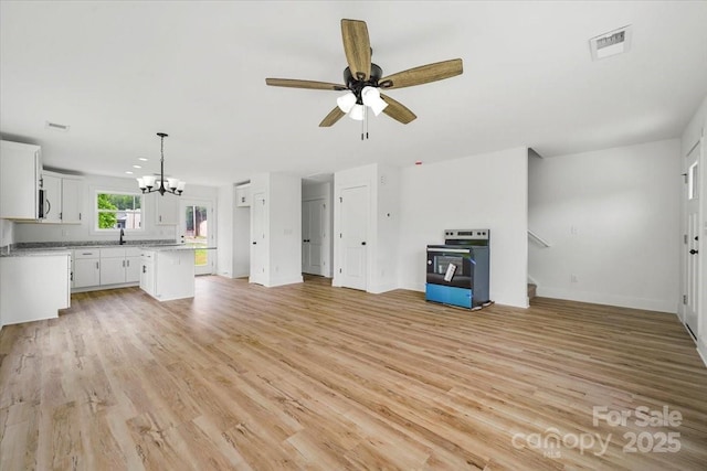 1600/1602 Bluff St, Albemarle, NC 28001 - unfurnished living room with a chandelier, light wood-style floors, a ceiling fan, and baseboards