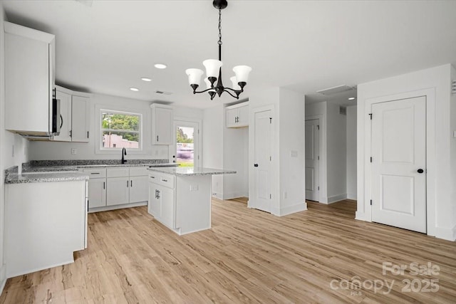 1600/1602 Bluff St, Albemarle, NC 28001 - kitchen with a sink, white cabinetry, a chandelier, a center island, and light wood-style floors