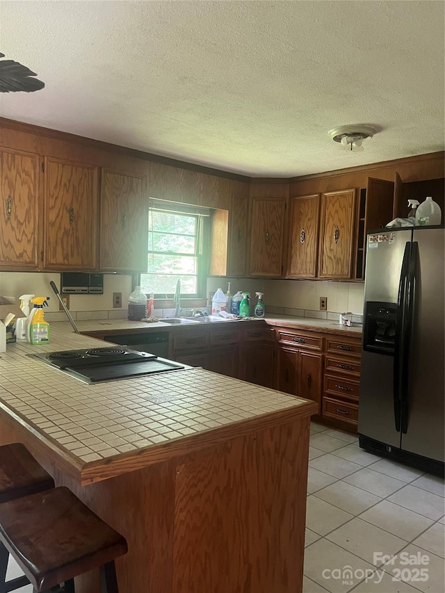 168 Pleasant Creek Dr, Cleveland, NC 27013 - kitchen with stainless steel fridge with ice dispenser, tile counters, a peninsula, a textured ceiling, and black electric cooktop