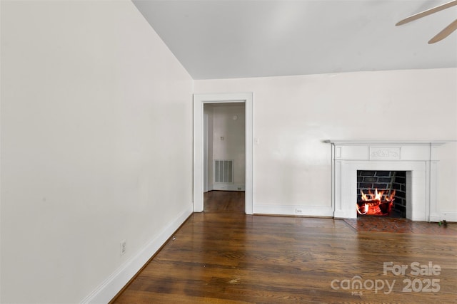505 Franklin Ave, Shelby, NC 28150 - unfurnished living room with wood finished floors, ceiling fan, a tiled fireplace, and baseboards
