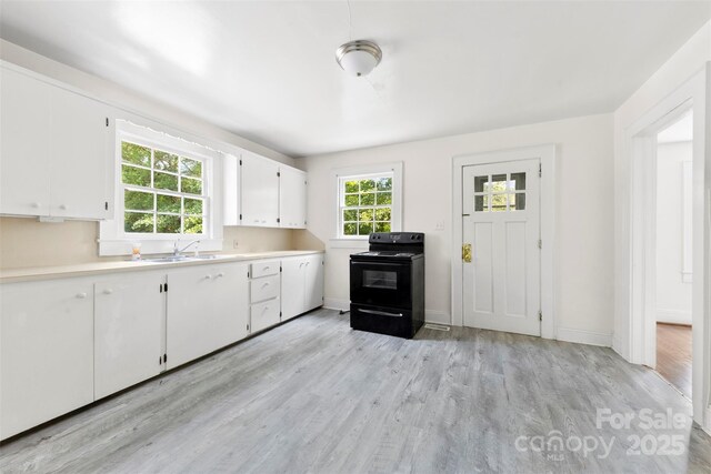 505 Franklin Ave, Shelby, NC 28150 - kitchen featuring electric range, light countertops, white cabinetry, light wood finished floors, and a sink