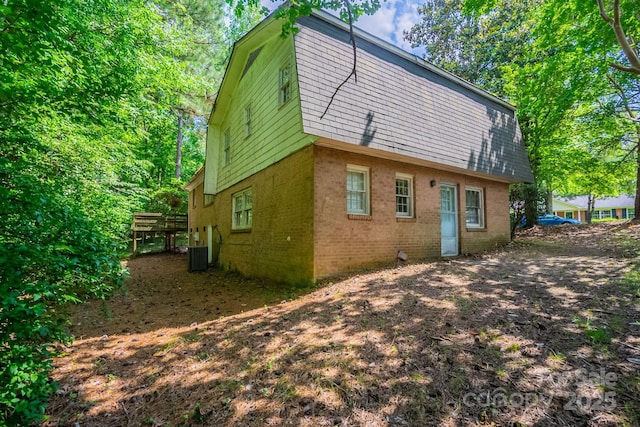 7320 Ritter Dr, Charlotte, NC 28270 - rear view of house with brick siding, a gambrel roof, and a wooden deck