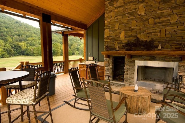 49 S Sundrops Trl, Cullowhee, NC 28723 - wooden deck featuring an outdoor stone fireplace, a wooded view, and outdoor dining space