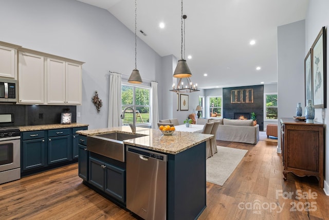 49 S Sundrops Trl, Cullowhee, NC 28723 - kitchen featuring appliances with stainless steel finishes, high vaulted ceiling, a fireplace, a center island with sink, and open floor plan