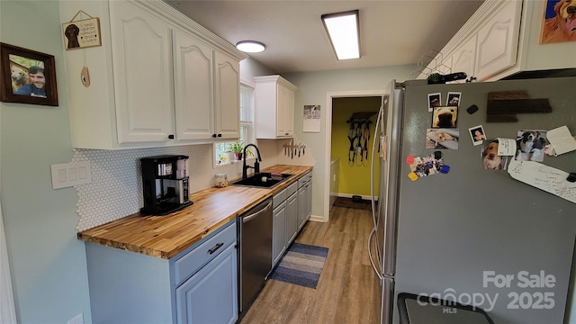 10 Haven Crest Ln, Fletcher, NC 28732 - kitchen with appliances with stainless steel finishes, a sink, butcher block counters, light wood finished floors, and tasteful backsplash