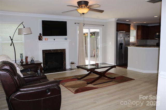 10726 Greenhead View Rd, Charlotte, NC 28262 - living room with light wood-style flooring, ceiling fan, a high end fireplace, healthy amount of natural light, and crown molding