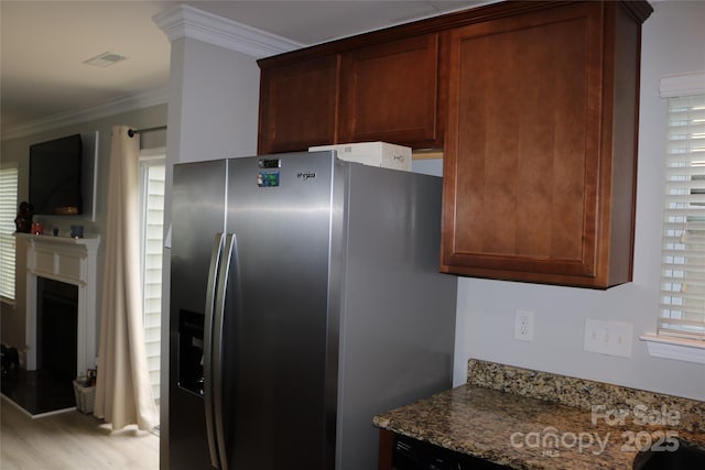 10726 Greenhead View Rd, Charlotte, NC 28262 - kitchen featuring stainless steel refrigerator with ice dispenser, ornamental molding, stone counters, light wood finished floors, and a fireplace